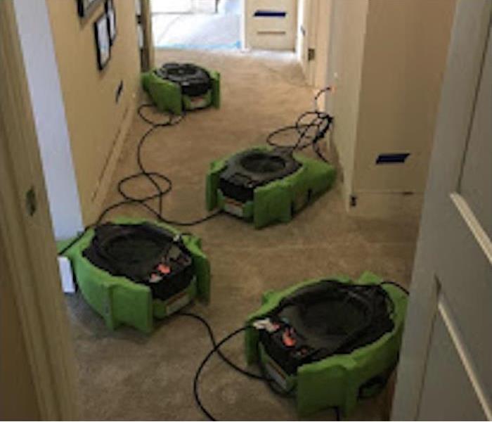 Air movers drying out the floor of a home that has been exposed from floodwaters